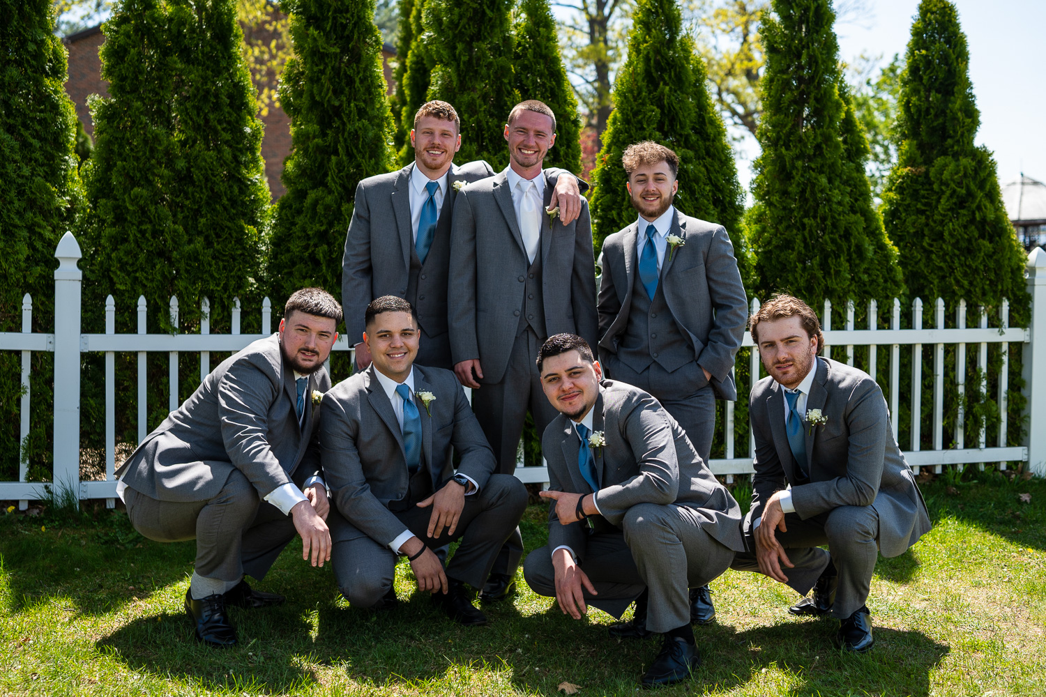 Groom and groomsmen posing before the lakeside wedding