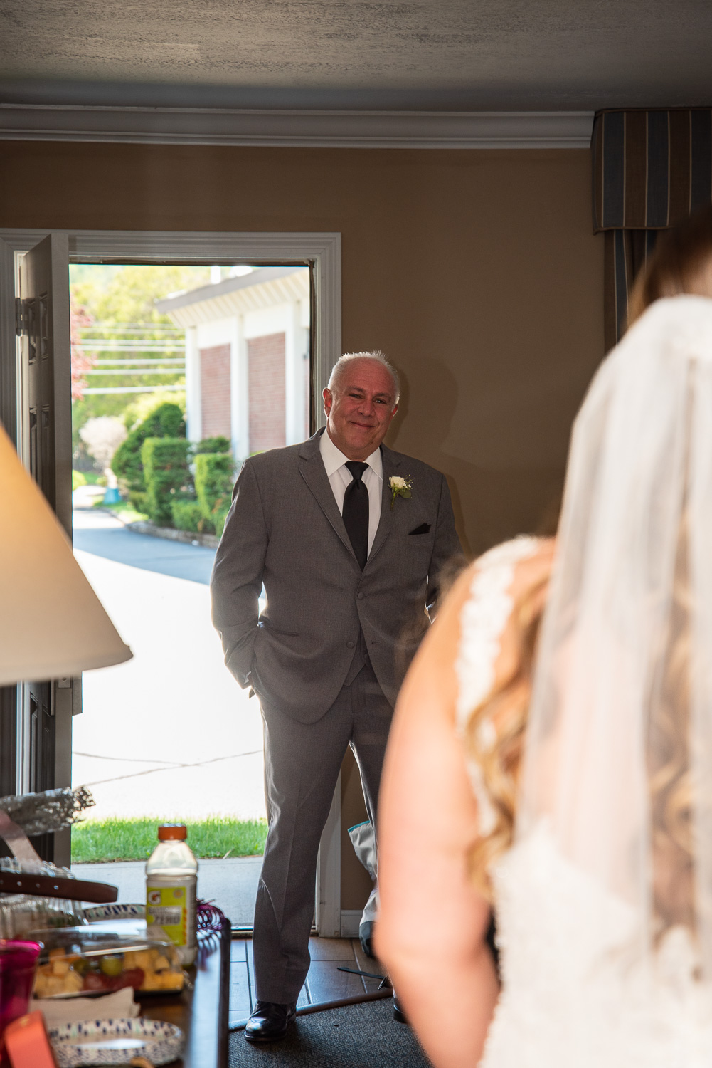 Brides' dad walking into the room to see the bride for the first time before the lakeside wedding