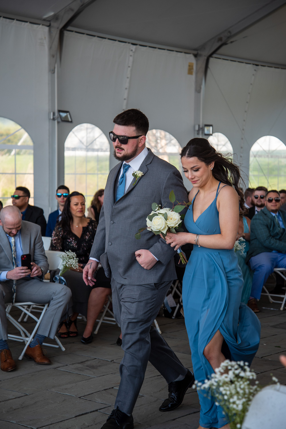 Groomsman walking bridesmaid down the aisle