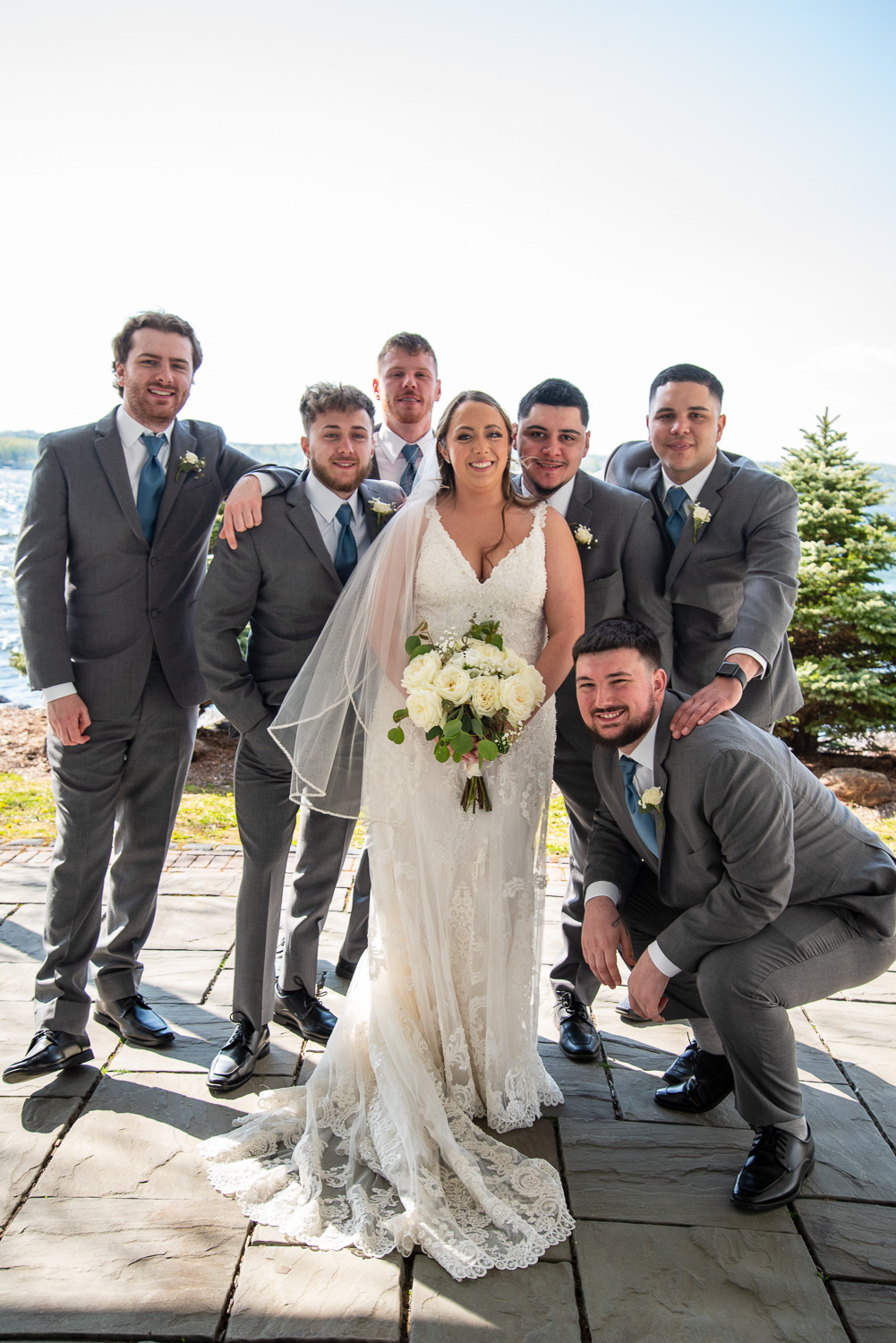 Bride with the groomsman at the lakeside wedding