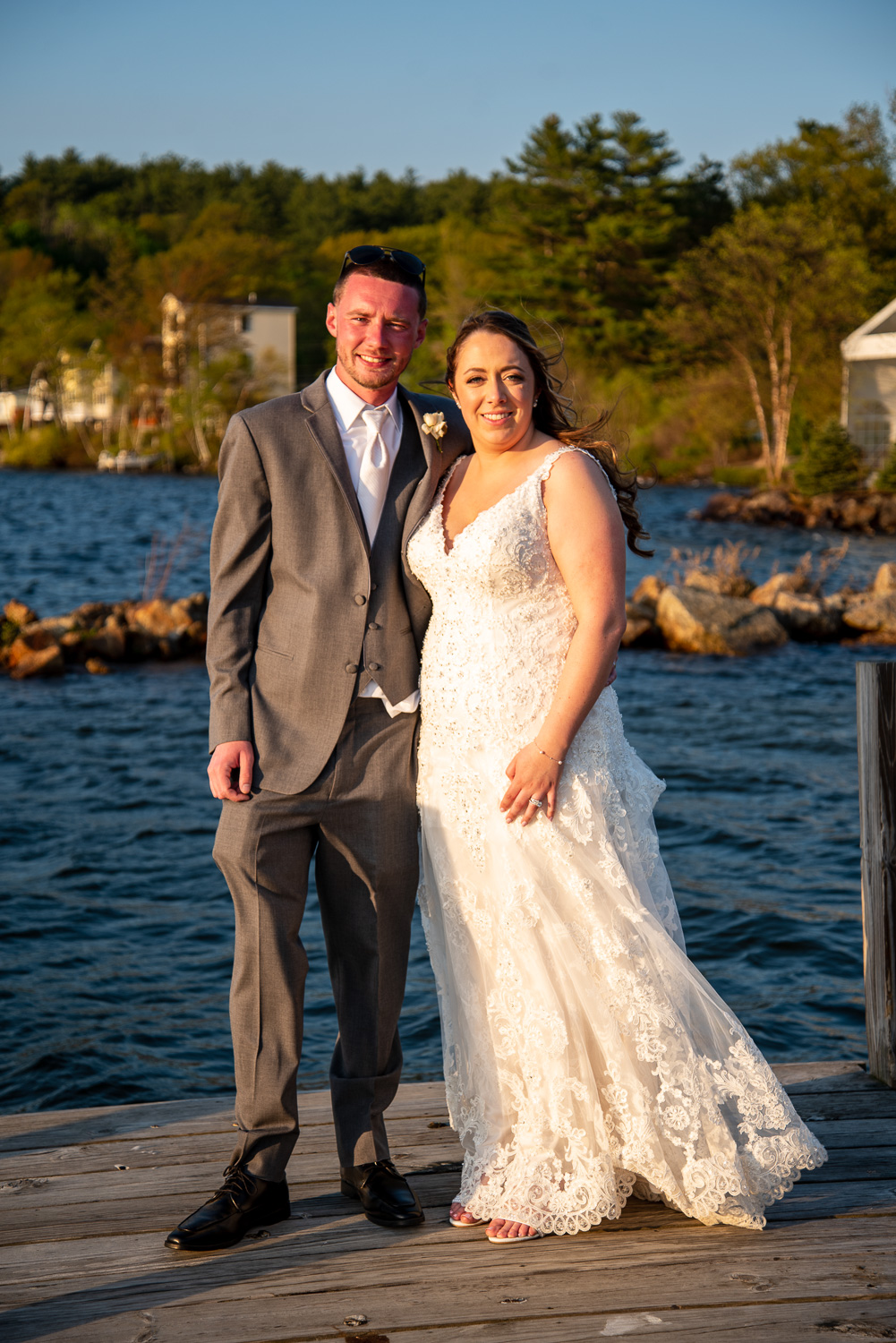 Bride and groom standing on a dock at the lakeside wedding