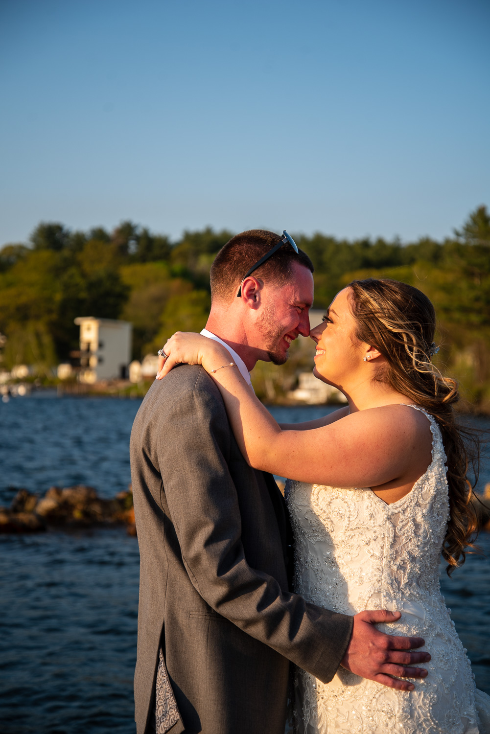 Bride and groom nose to nose smiling on the dock at the lakeside wedding