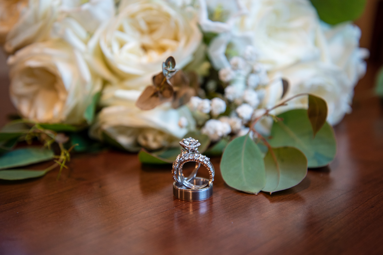 Bride's and groom's rings in front of bouquet at the lakeside wedding 
