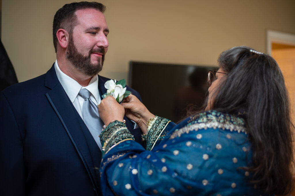 groom getting his boutonnière on before his wedding with a view