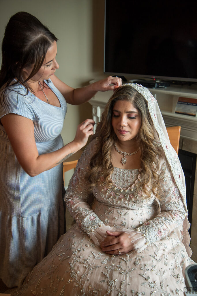 bride getting her veil put on before a. wedding with a view 