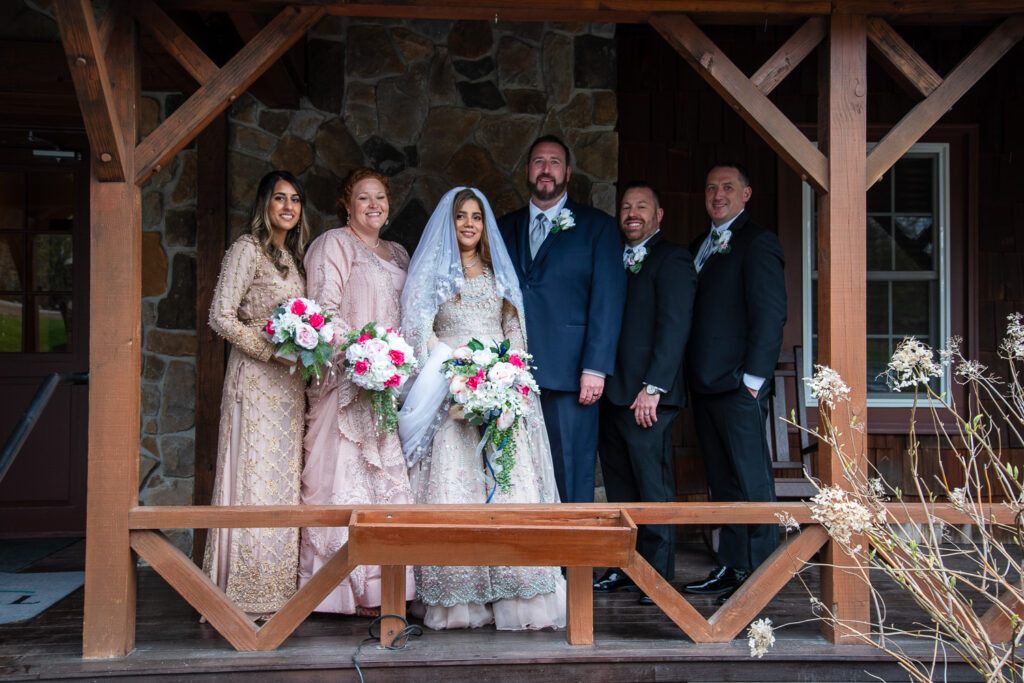 bridal party with bride and groom on the front porch of Steele Hill Resort the perfect spot for a wedding with a view