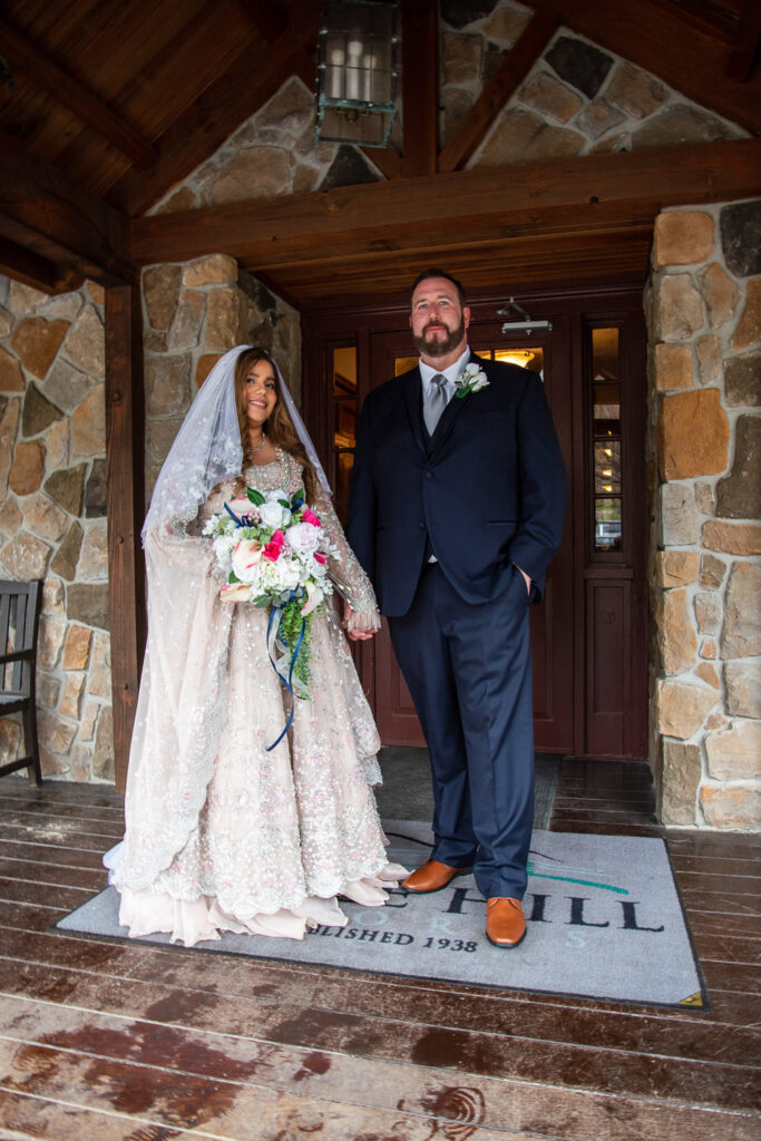 bride and groom holding hands on the front porch of Steele Hill Resort, the perfect place for a wedding with a view 