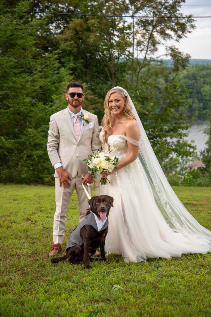 The bride and groom and their dog after the wedding ceremony of the summer getaway wedding