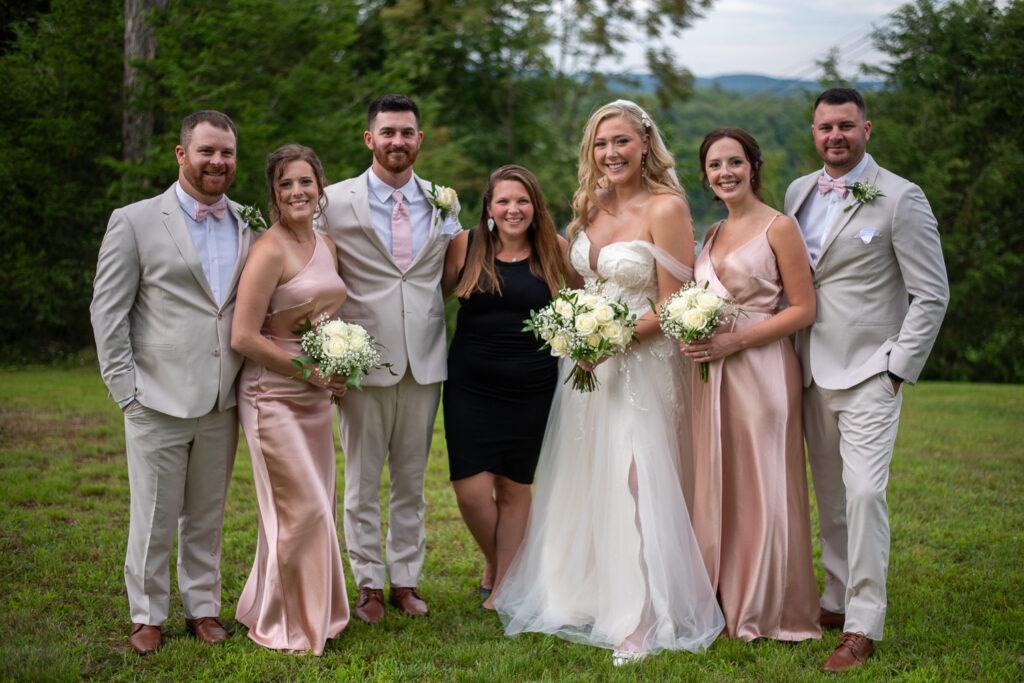 The bride and grooms family with the photographer at the summer getaway wedding