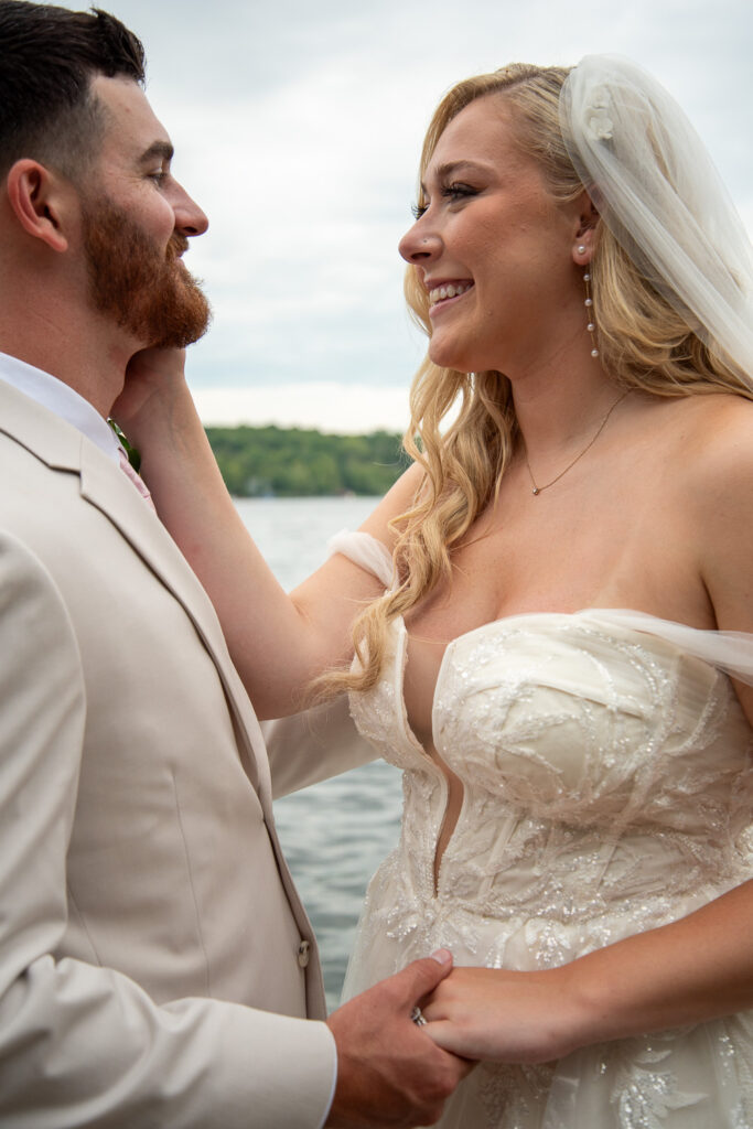 The bride and groom looking into each others eyes on the dock after the summer getaway wedding